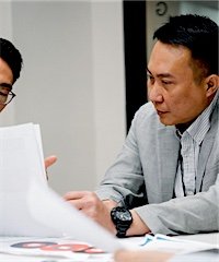 Two colleagues carefully reviewing paperwork together