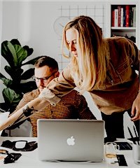 One colleague helping another at their desk