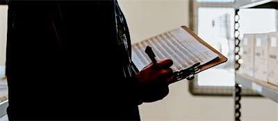 A supervisor reviewing work against a checklist