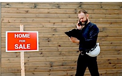 A real estate agent with a property for-sale sign