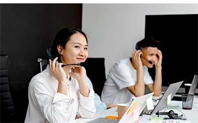 Customer service agents working with headsets in an office
