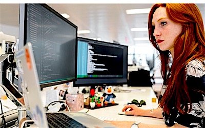 A developer building a website across two monitors