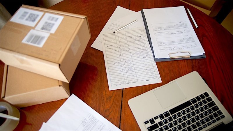 A business owner working through paperwork at a busy desk