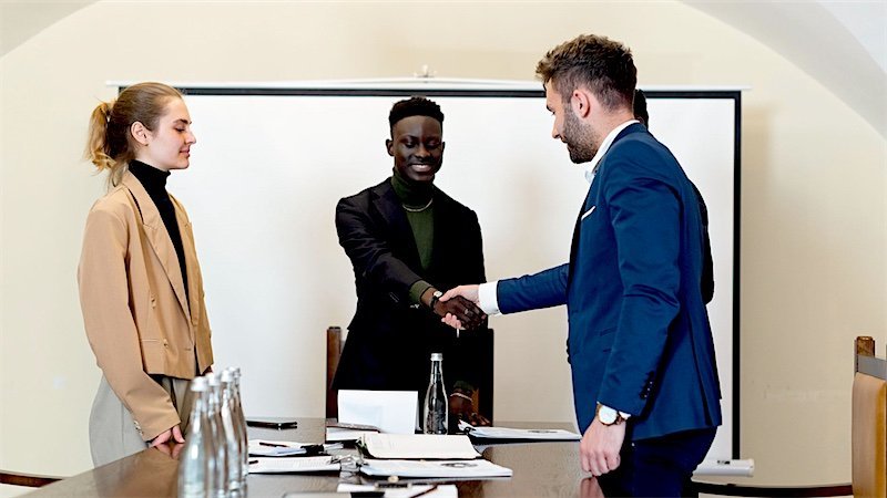 Two people meeting across a desk in an office