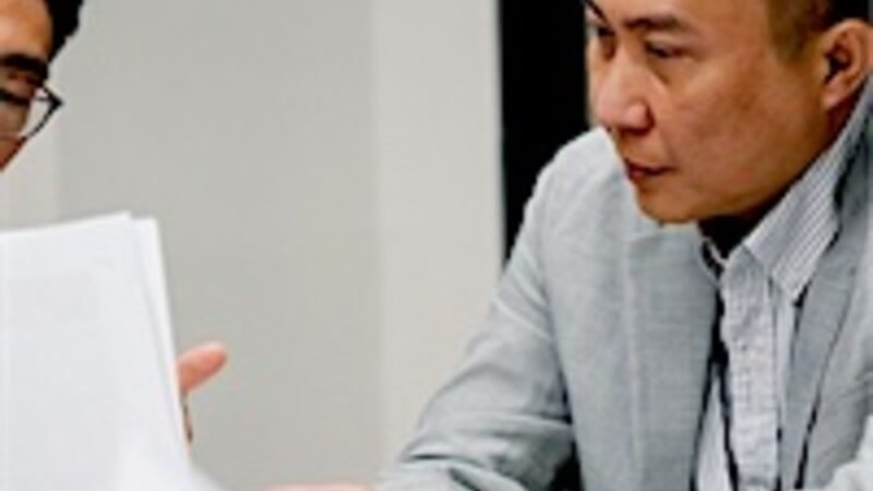 A business owner reading a document closely across a meeting table