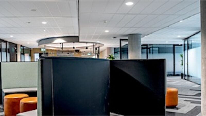 An empty office workspace with nobody at the desks