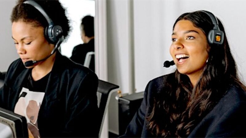 Two support staff wearing headsets working a shift together