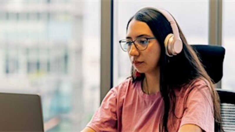 A virtual assistant working at a desk with a headset and laptop