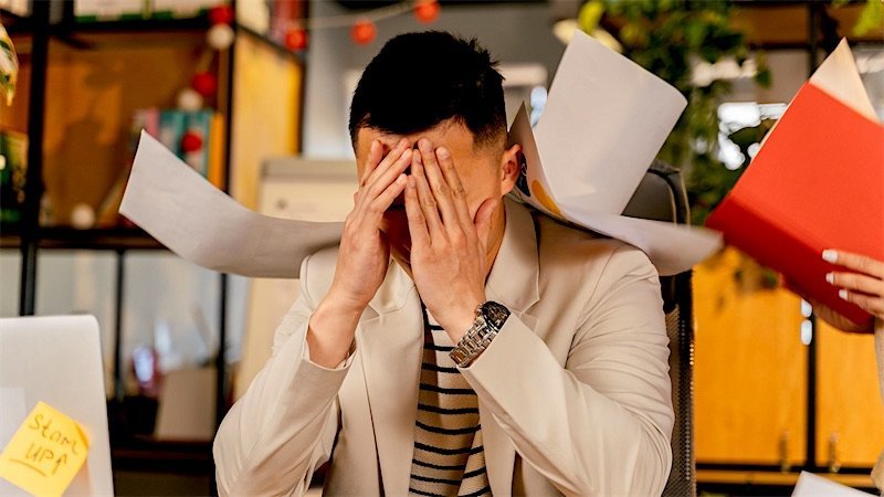 A business owner at a desk covered in paperwork